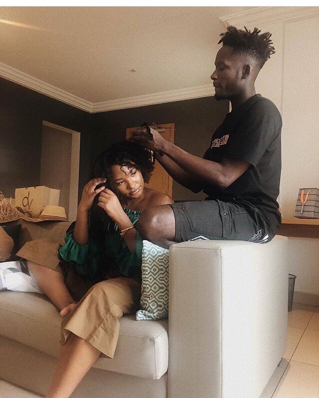 How Romantic! See Photo of Mr. Eazi Making his Girlfriend’s Hair